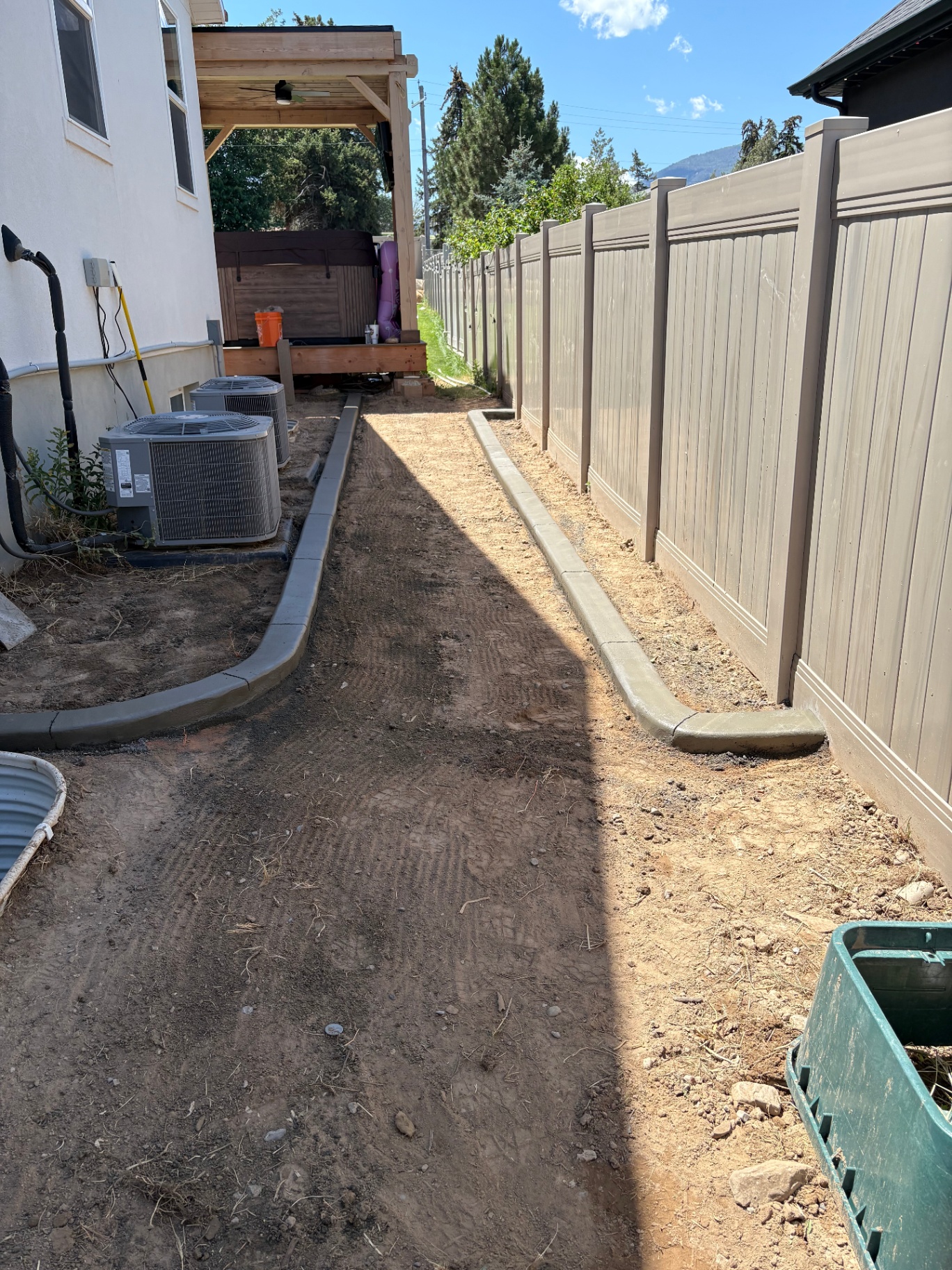 Utah side-yard with freshly poured white concrete curbing ready for sod, mulch, and landscape plantings.
